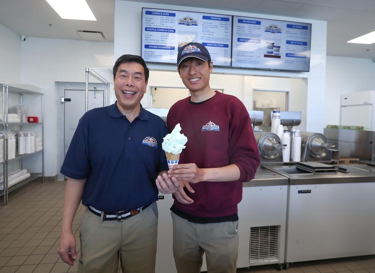 Neil Liu and son and employee Nicholas, from left, during the grand opening Friday of Stricklands Ice Cream in Costa Mesa.
