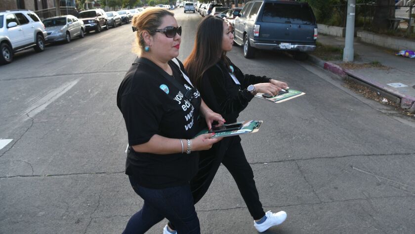 April Camacho, left, and Melyna Gutierrez of the group InnerCity Struggle canvass Boyle Heights to urge Angelenos to vote yes on Measure EE.