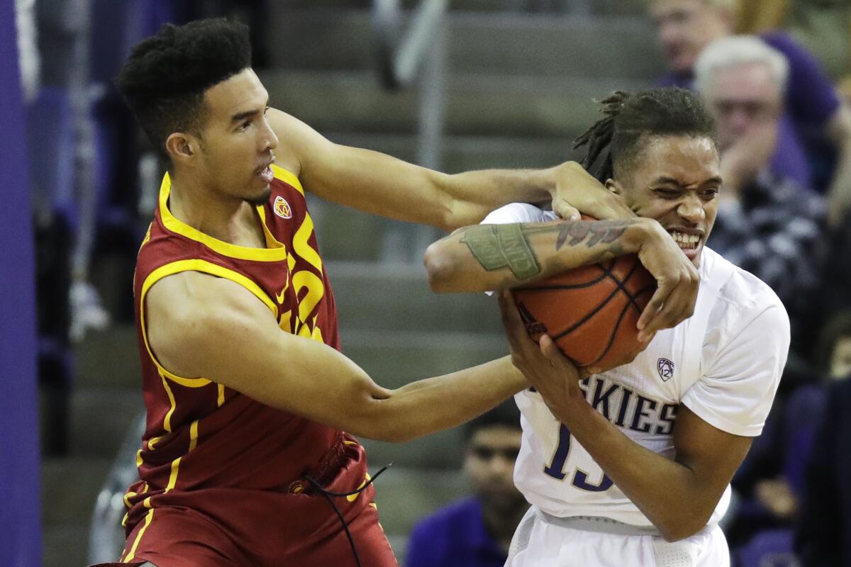 USC forward Isaiah Mobley, left, and Washington forward Hameir Wright battle for the ball during the Trojans' 72-40 loss Sunday.