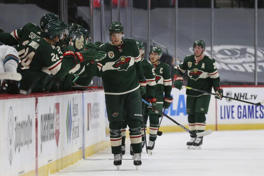 Minnesota Wild's Nick Bjugstad (27) high fives teammates on the bench after scoring a goal against the San Jose Sharks in the second period of an NHL hockey game Sunday, Jan. 24, 2021, in St. Paul, Minn. (AP Photo/Stacy Bengs)