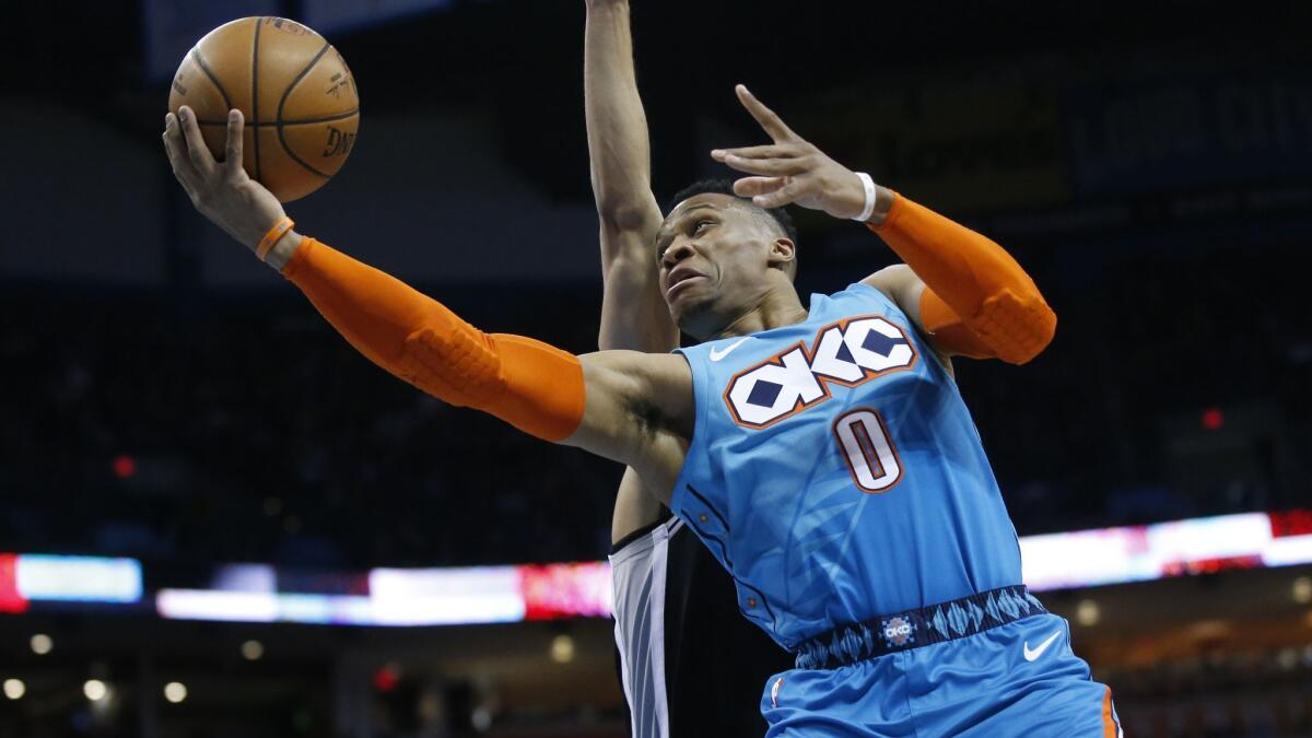 Thunder guard Russell Westbrook attempts a reverse layup against Spurs guard Derrick White during the first half Saturday.