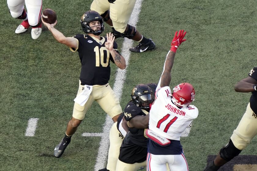Wake Forest quarterback Sam Hartman (10) looks to pass over Liberty defensive end Durrell Johnson (11) during the first half of an NCAA college football game in Winston-Salem, N.C., Saturday, Sept. 17, 2022. (AP Photo/Chuck Burton)