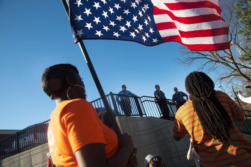 Demonstrators outside the police station in Ferguson, Mo., on March 15, the same day the St. Louis County prosecutor announced that Jeffrey Williams had been arrested in the shooting of two officers.