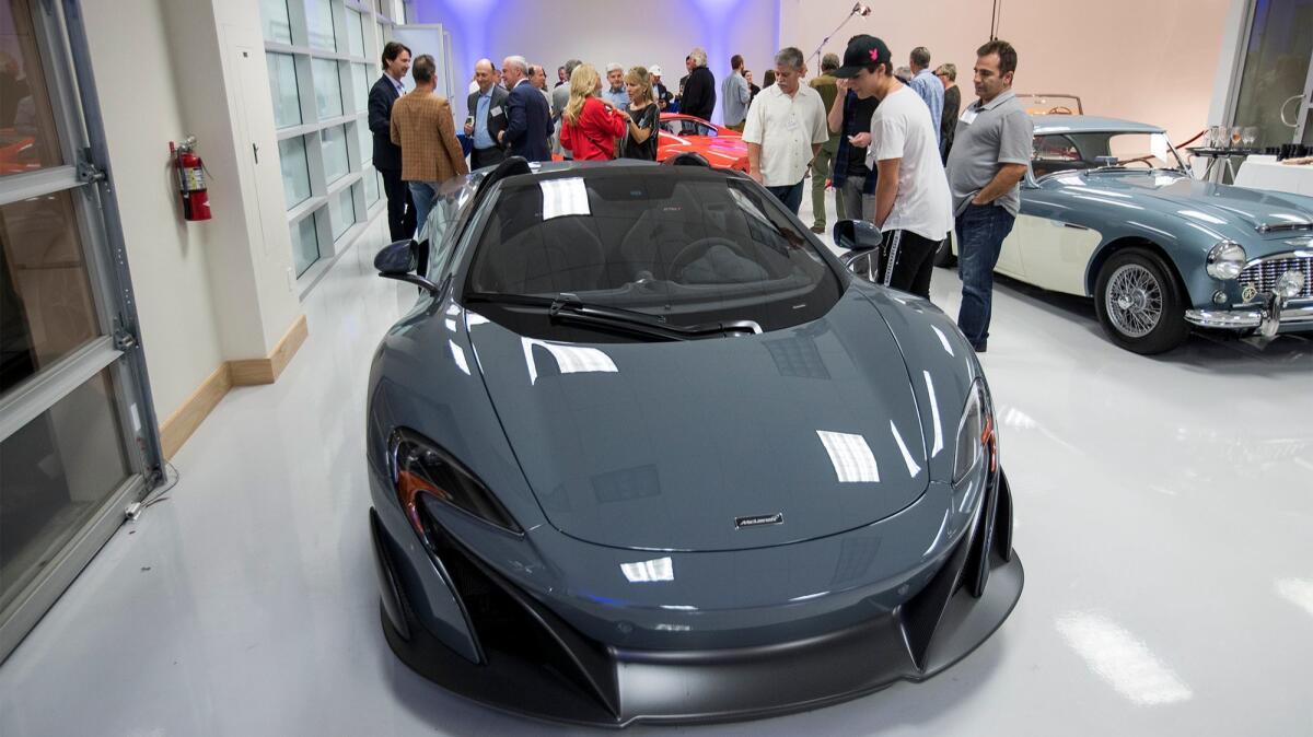 Guests look at the 2016 McLaren 675 LT Spider during the grand opening of Morris & Welford on Dec. 7.