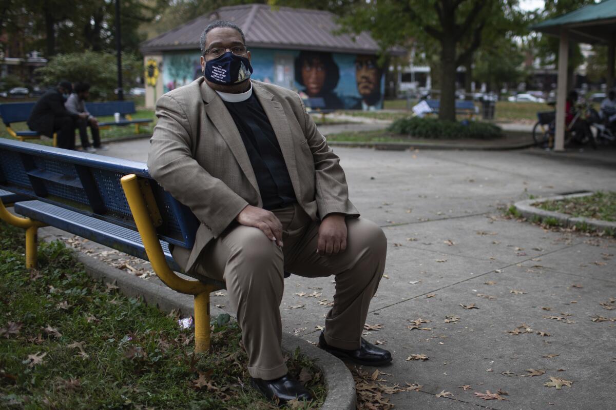 Bishop Duane Royster sits on a bench in a park in Philadelphia