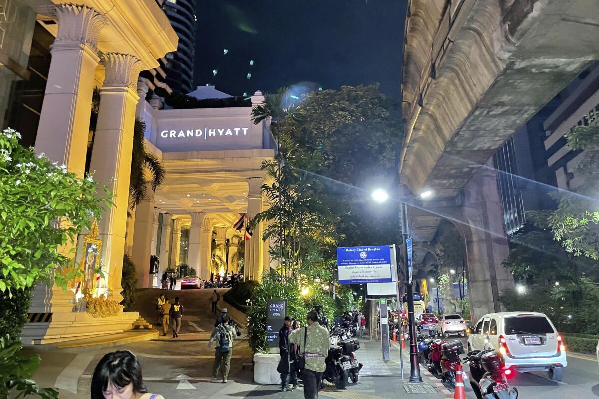 People walk outside the Grand Hyatt Erawan Hotel in Bangkok, Thailand.