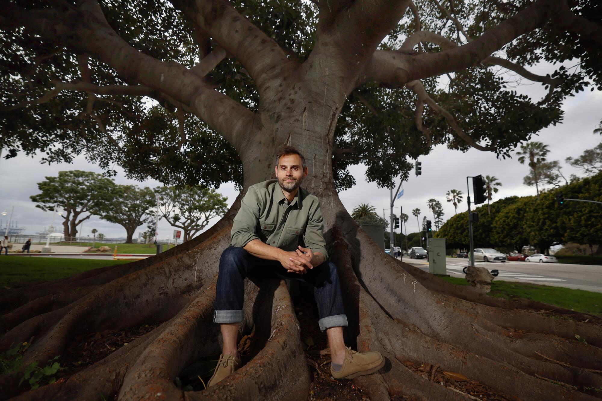 Paul Piff sits at the base of a tree.