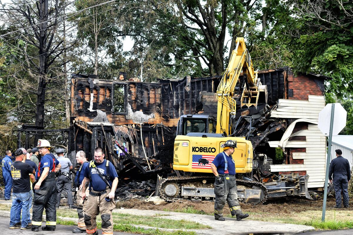 Crews work to demolish a house that was destroyed by a fatal fire on the 700 block of 1st Street in Nescopeck, Pa., Friday, Aug. 5, 2022. Multiple people are feared dead after a house fire early Friday in northeastern Pennsylvania, according to a volunteer firefighter who responded and said the victims were his relatives. A criminal investigation is underway, police said. (Sean McKeag/The Citizens' Voice via AP)