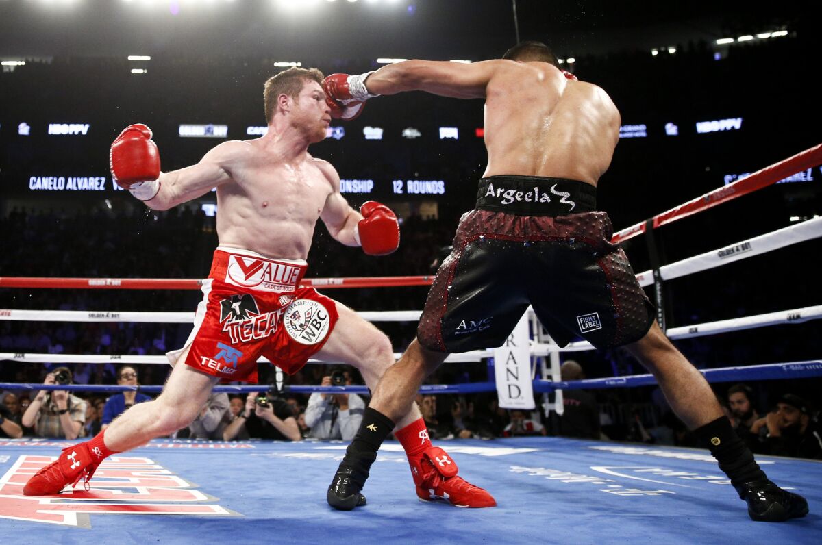 Canelo Alvarez, left, and Amir Khan trade punches during their WBC middleweight championship bout in Las Vegas on May 7.