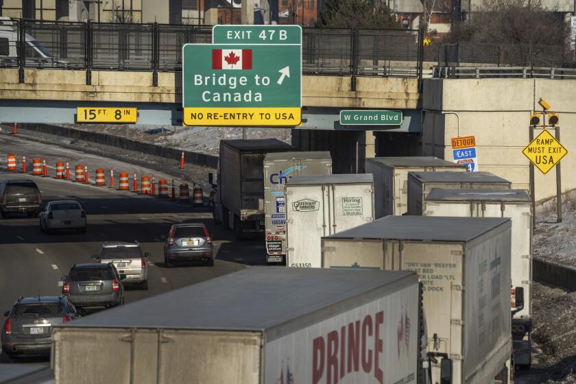 A small line of semi-trailer trucks line up along northbound I-75 in Detroit as the Ambassador Bridge entrance is blocked off for travel to Canada on Tuesday, Feb. 8, 2022. Canadian lawmakers are expressing increasing worry about the economic effects of disruptive COVID-19 demonstrations. They spoke Tuesday after the busiest border crossing between the U.S. and Canada became partially blocked by truckers protesting vaccine mandates and other coronavirus restrictions. The Ambassador Bridge between Detroit and Windsor, Ontario, carries 25 percent of trade between the two countries. (Ryan Garza/Detroit Free Press via AP)