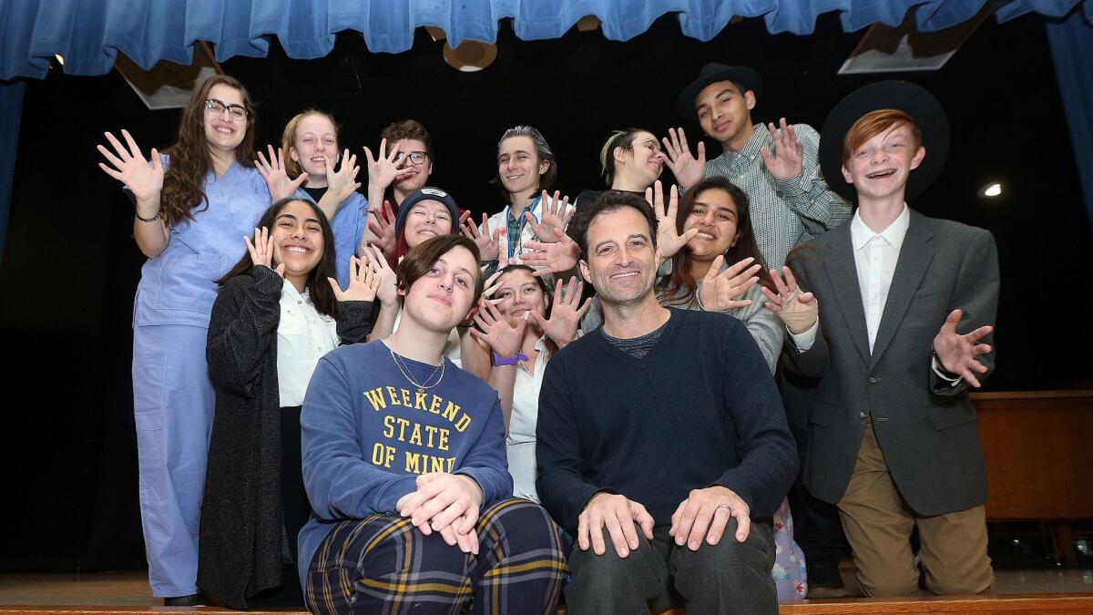 Burbank High School student Parker Swierczysnki, with performing arts director Donovan Glover, sit with the cast of Parker's sister's self-written one-act play at Burbank High on Monday. Parker's sister Evie was a drama student at the high school who passed away in October.