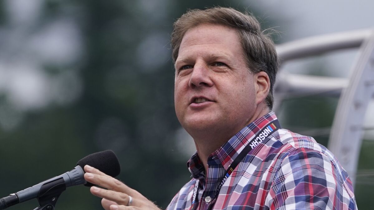 FILE— Republican New Hampshire Gov. Chris Sununu addresses racing fans at a NASCAR Cup Series auto race, July 18, 2021, in Loudon, N.H. Gov. Sununu in a speech in Washington Saturday, April 2, 2022 called Donald Trump “crazy” and joked that if the former Republican president was admitted into a mental hospital “he’s not getting out.” (AP Photo/Charles Krupa, File)