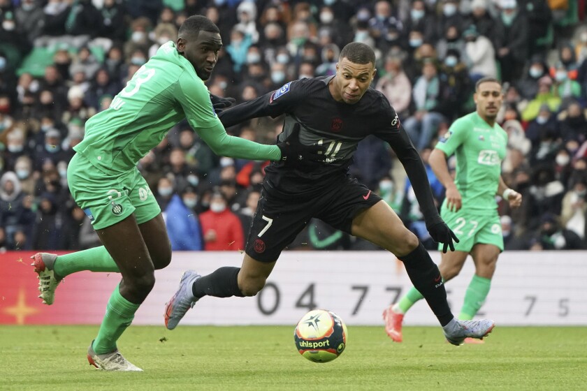 PSG's Kylian Mbappe, right, challenges for the ball with Saint-Etienne's Alpha Sissoko during the French League One soccer between Saint-Etienne and Paris Saint Germain, in Saint-Etienne, central France, Sunday, Nov. 28, 2021. (AP Photo/Laurent Cipriani)