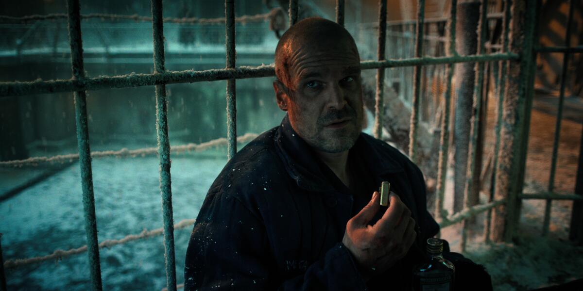 A beaten and dirty man (David Harbour) in a prison cell.