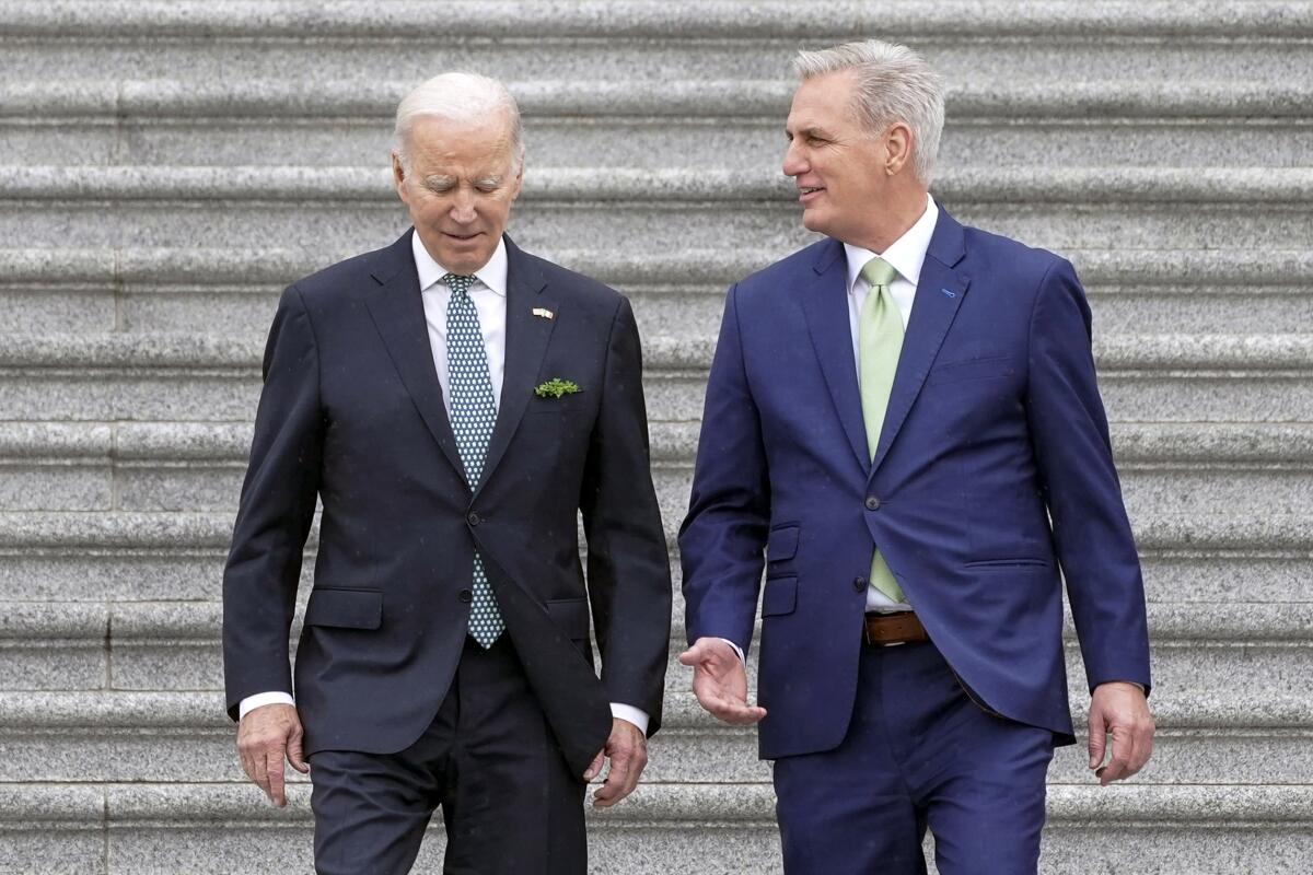 President Biden and House Speaker Kevin McCarthy walk down the steps of the U.S. Capitol.