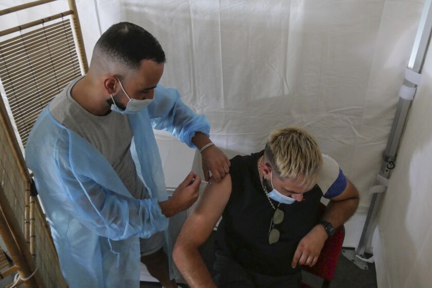 A man receives a Pfizer COVID-19 vaccine at a vaccination center in Carry le Rouet, southern France, Friday, July 23, 2021. In France locals and tourists need now a special COVID pass to visit museums or movie theaters, the first step in a new campaign against what the government calls a "stratospheric" rise in delta variant infections. (AP Photo/Nicolas Garriga)