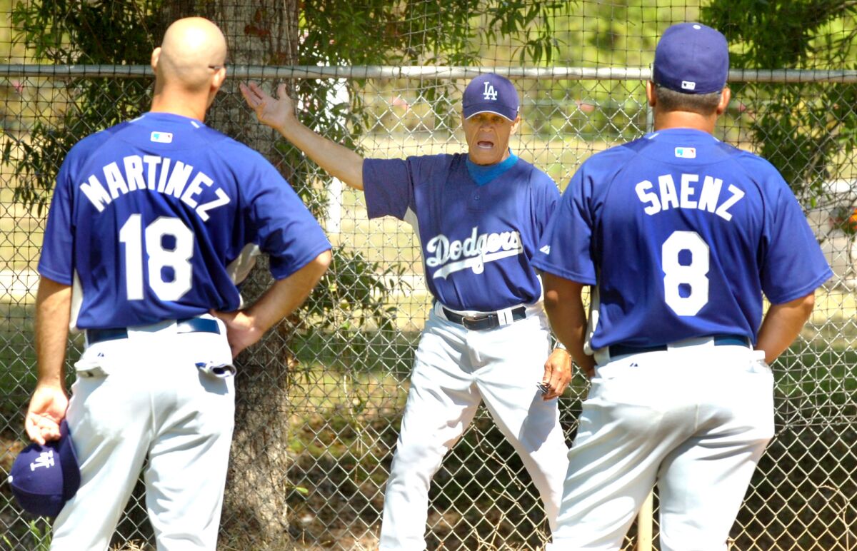 Ramon Martinez, à gauche et Olmedo Saenz, à droite, écoutent l'instructeur de course de base Maury Wills donner des pointeurs.