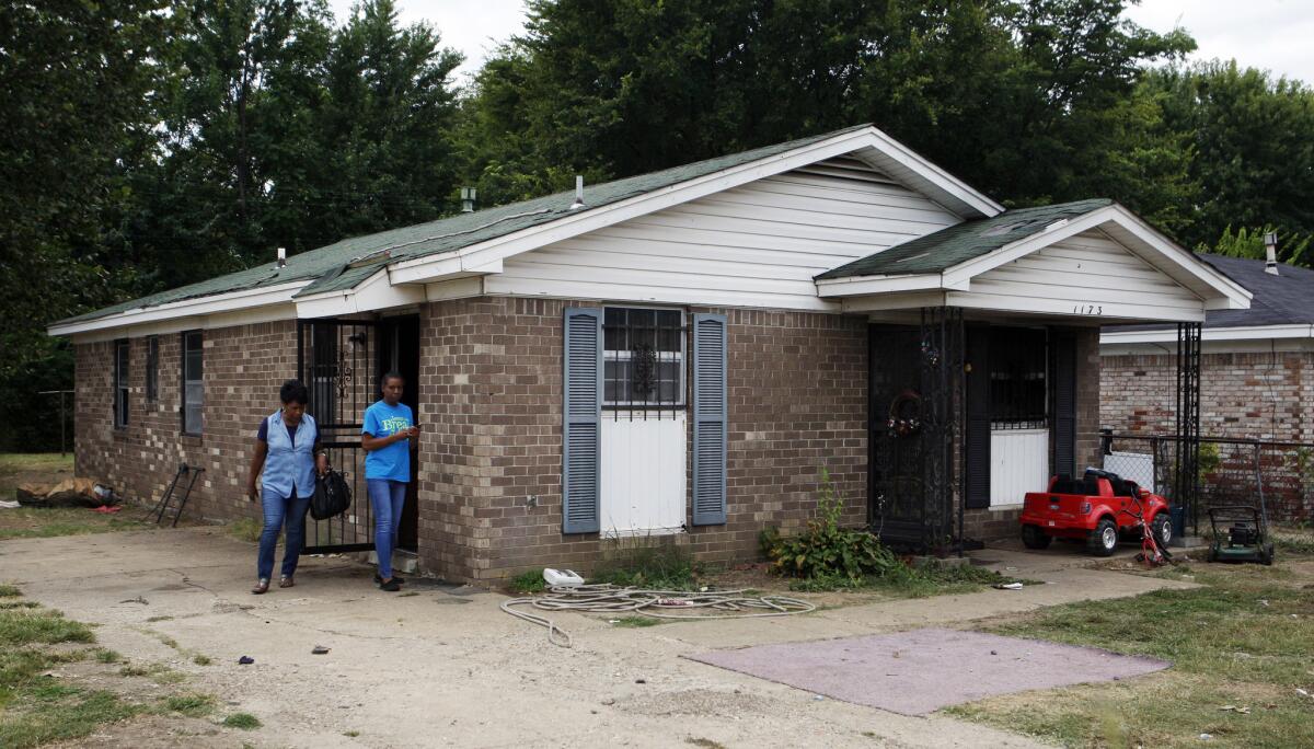 Pastor Mary Moore, left, and Janie Hendrix view a home where a fire killed nine people in Memphis, Tenn., on Sept. 12.