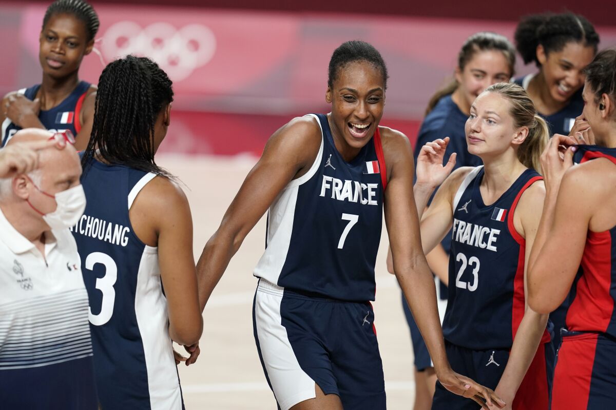 France's Sandrine Gruda (7) celebrates with teammates at the end of a women's basketball quarterfinal round game against Spain at the 2020 Summer Olympics, Wednesday, Aug. 4, 2021, in Saitama, Japan. (AP Photo/Charlie Neibergall)
