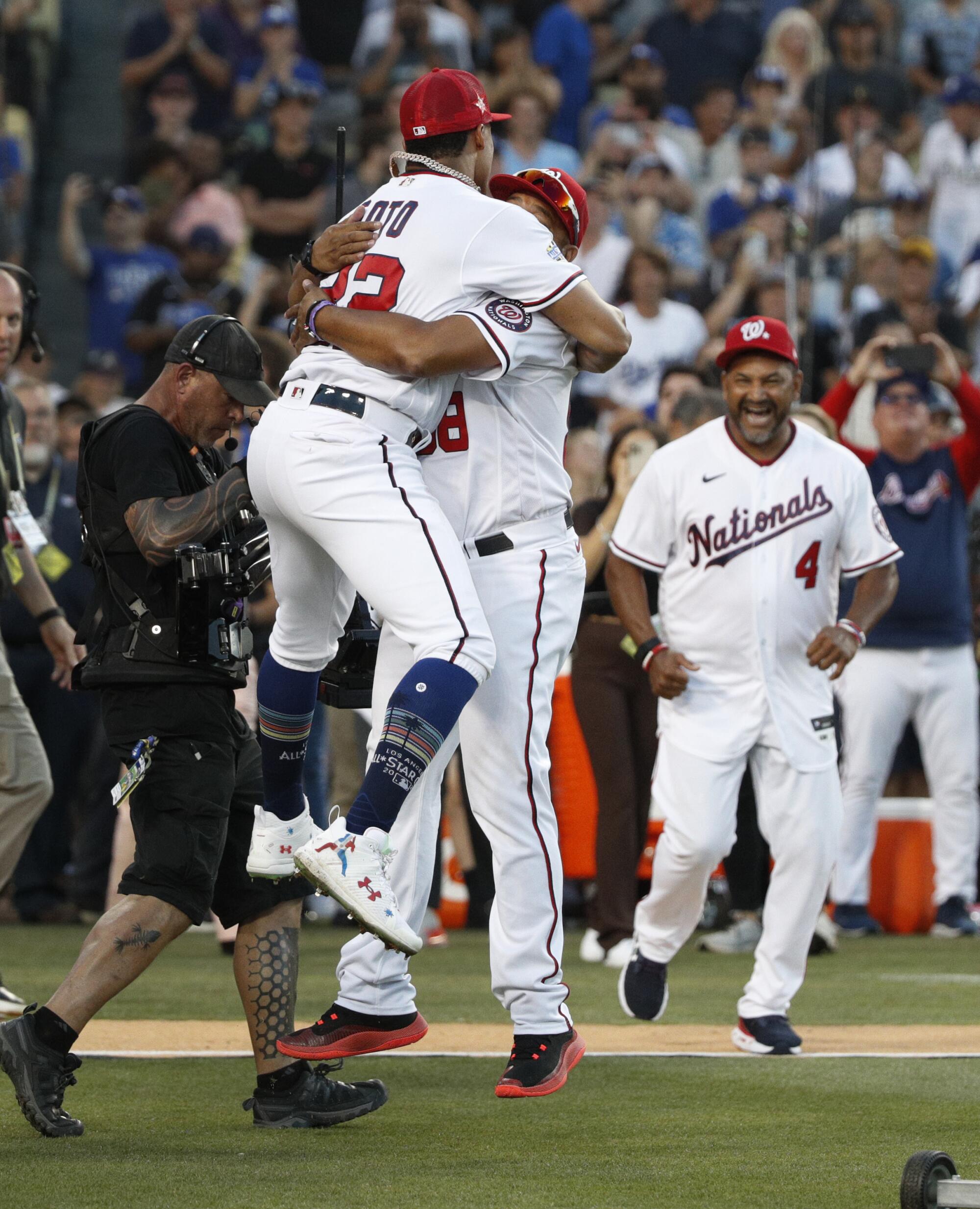 Washington Nationals' Juan Soto leaps into a teammate's arms after winning the Home Run Derby.
