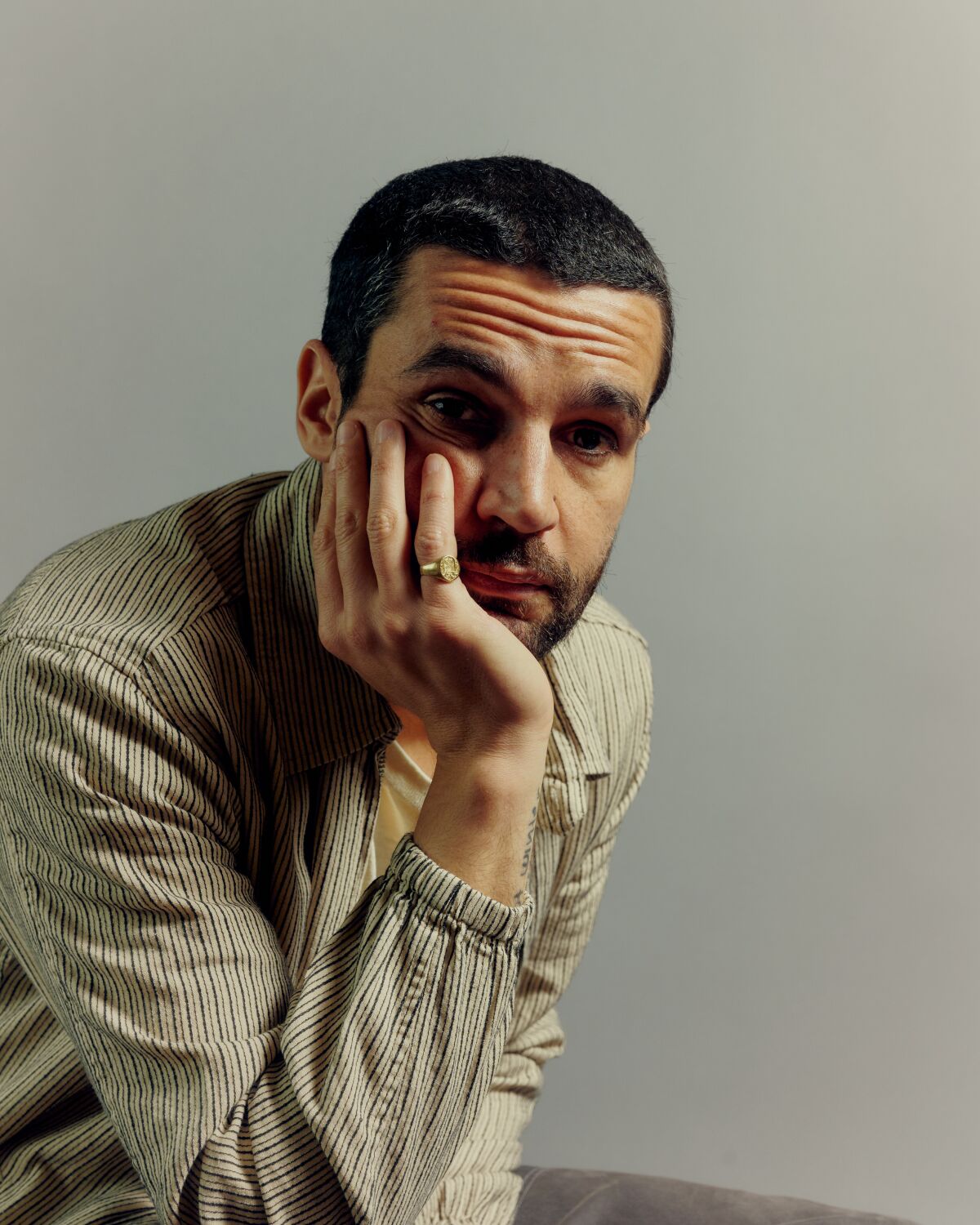 Actor Christopher Abbott with his hand under his chin.