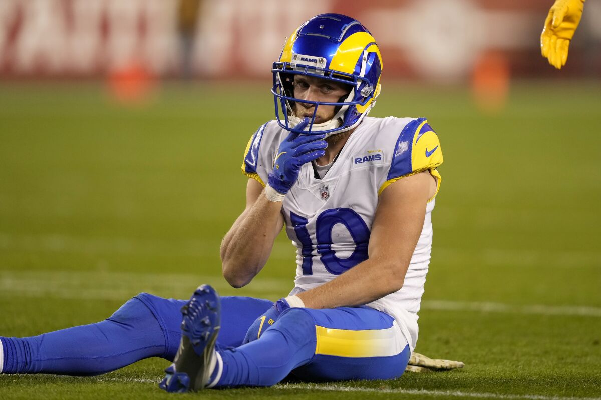 Rams wide receiver Cooper Kupp sits on the field after an incomplete pass.