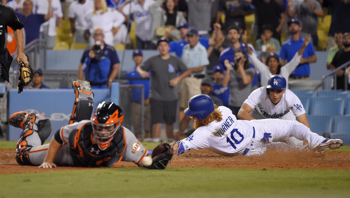 Dodgers' Justin Turner scores the winning run in front of teammate Corey Seager and behind San Francisco Giants catcher Buster Posey on July 30.