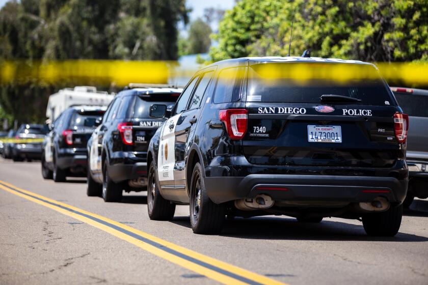 Police vehicles staged at the corner of 48th Street and Hilltop Drive on Friday, August 6, 2021. Police are at a standoff with a Laotian male armed with a machete inside a home, along with three other females, according to SDPD Captain Manny Del Toro.