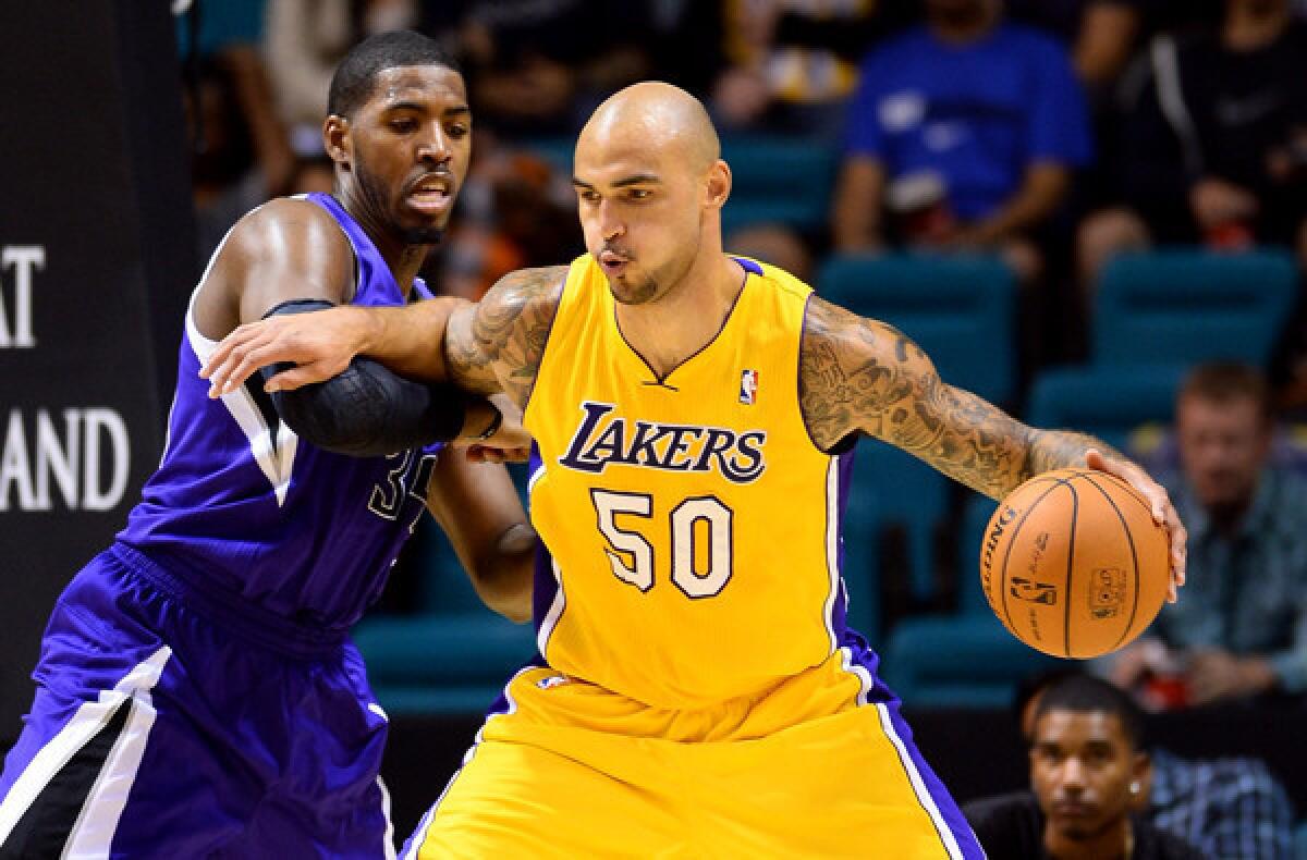 Lakers center Robert Sacre works in the post against Kings power forward Jason Thompson during a preseason game.