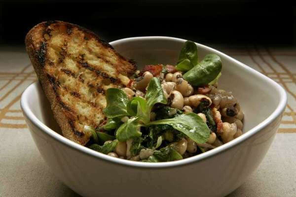 A warm salad of black-eyed peas with wilted greens and bacon.