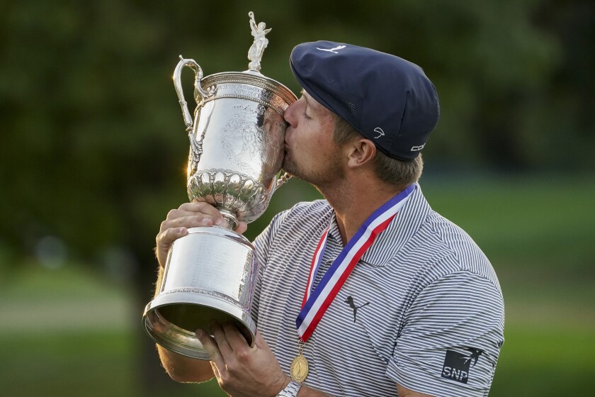Bryson DeChambeau kisses the U.S. Open winner's trophy after winning last year's tournament at Winged Foot.