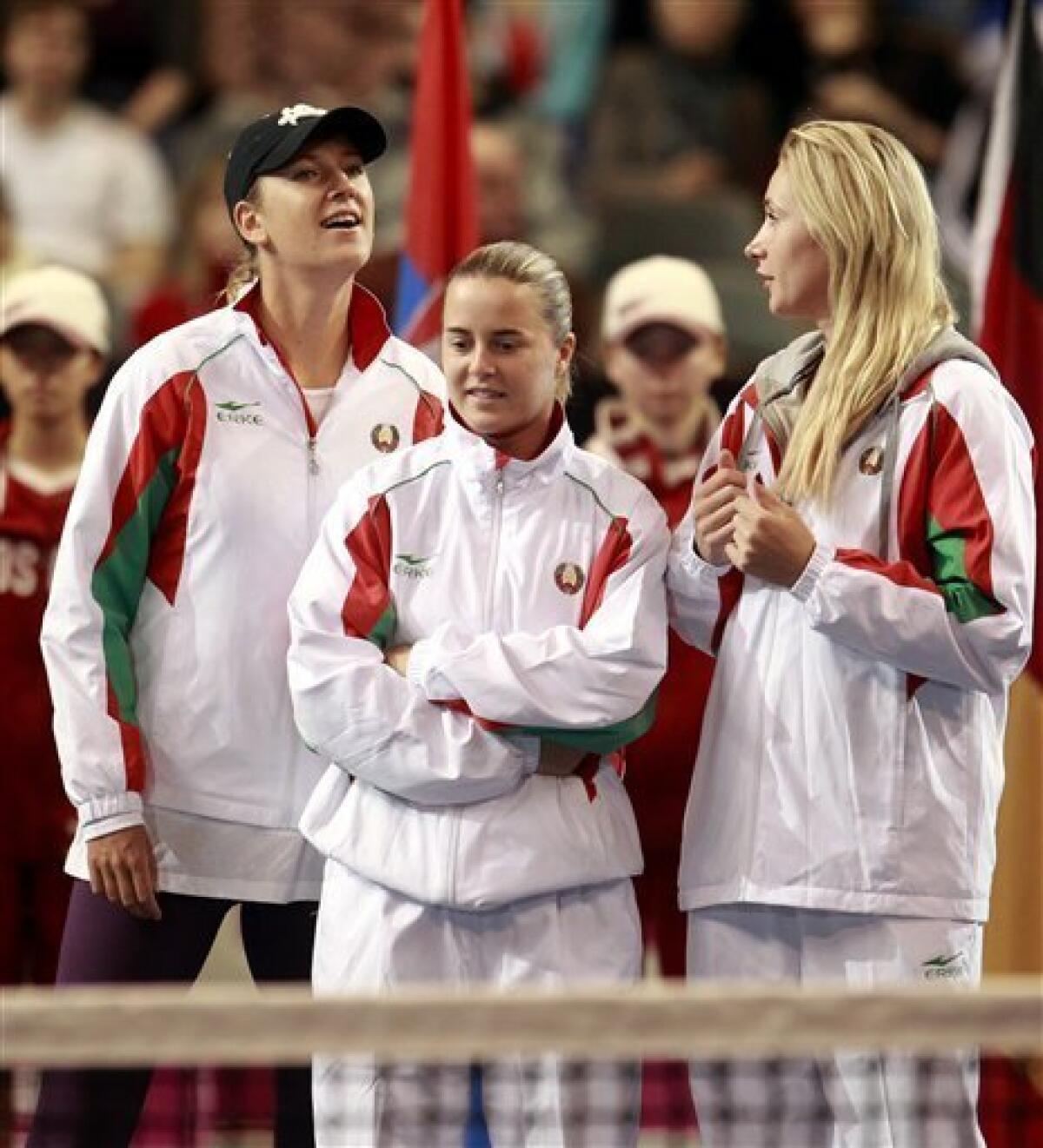 Victoria Azarenka, left, Anastasia Yakimova, center, and Olga Govortsova, all of Belarus, stand together before first-round Fed Cup tennis matches against the United States, in Worcester, Mass., Sunday, Feb. 5, 2012. Azarenka is the world's top ranked player. (AP Photo/Steven Senne)