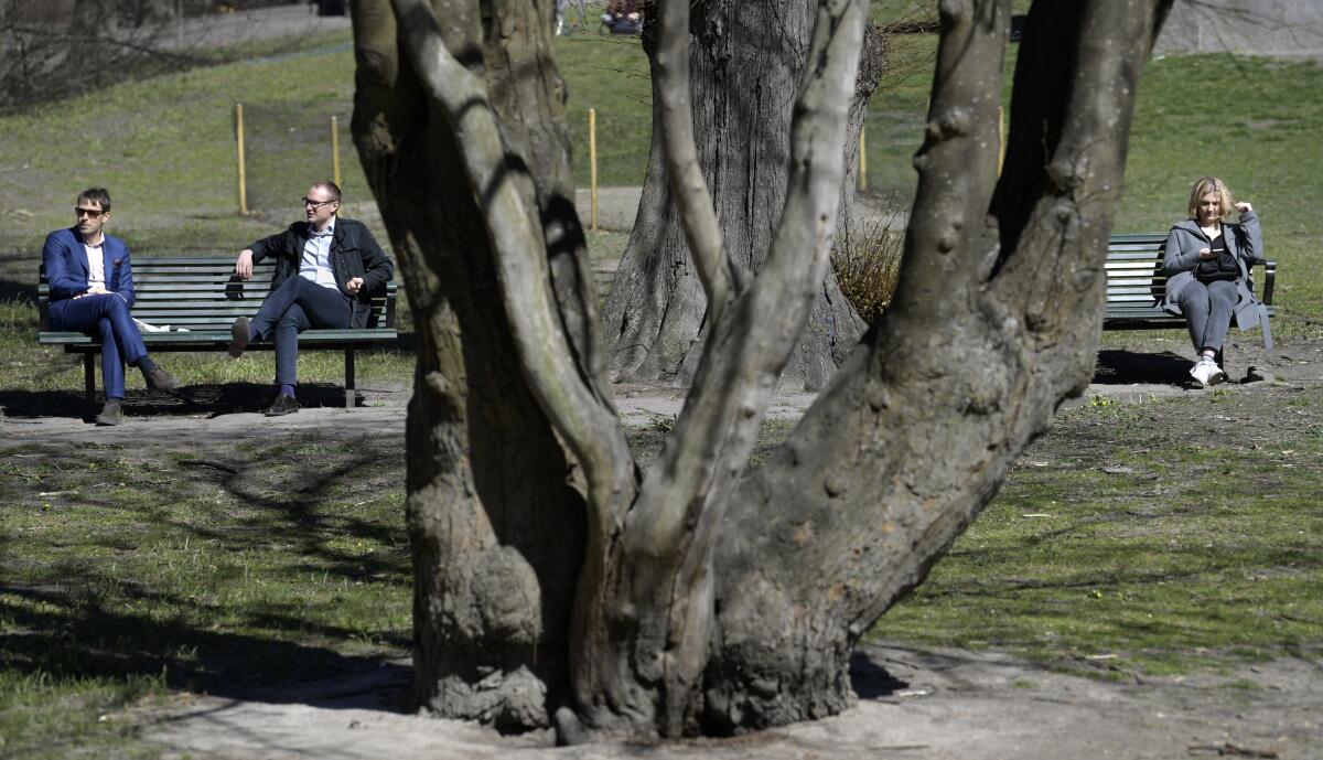 Unas personas se asolean en el parque Humlegarden, en Estocolmo, Suecia, el 22 de abril de 2020.