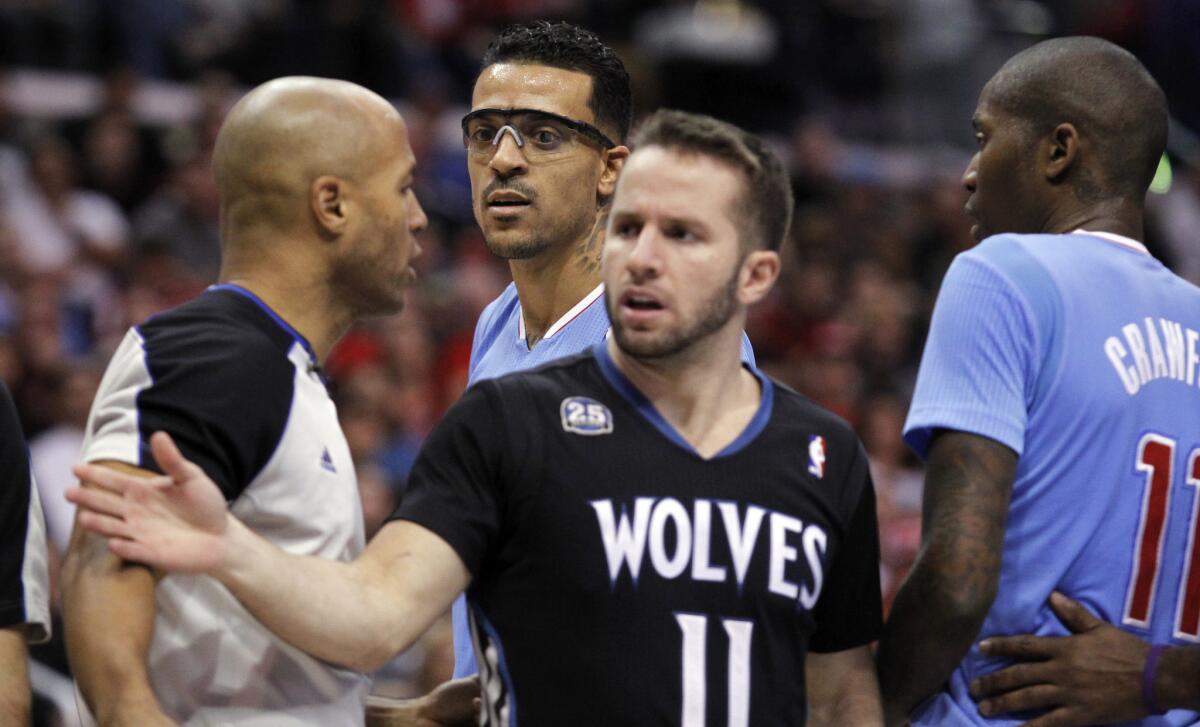Clippers forward Matt Barnes (in goggles) stares at referee Marc Davis after being called for a flagrant foul on Sunday as Timberwolves guard J.J. Barea and Clippers guard Jamal Crawford try to calm teammates.