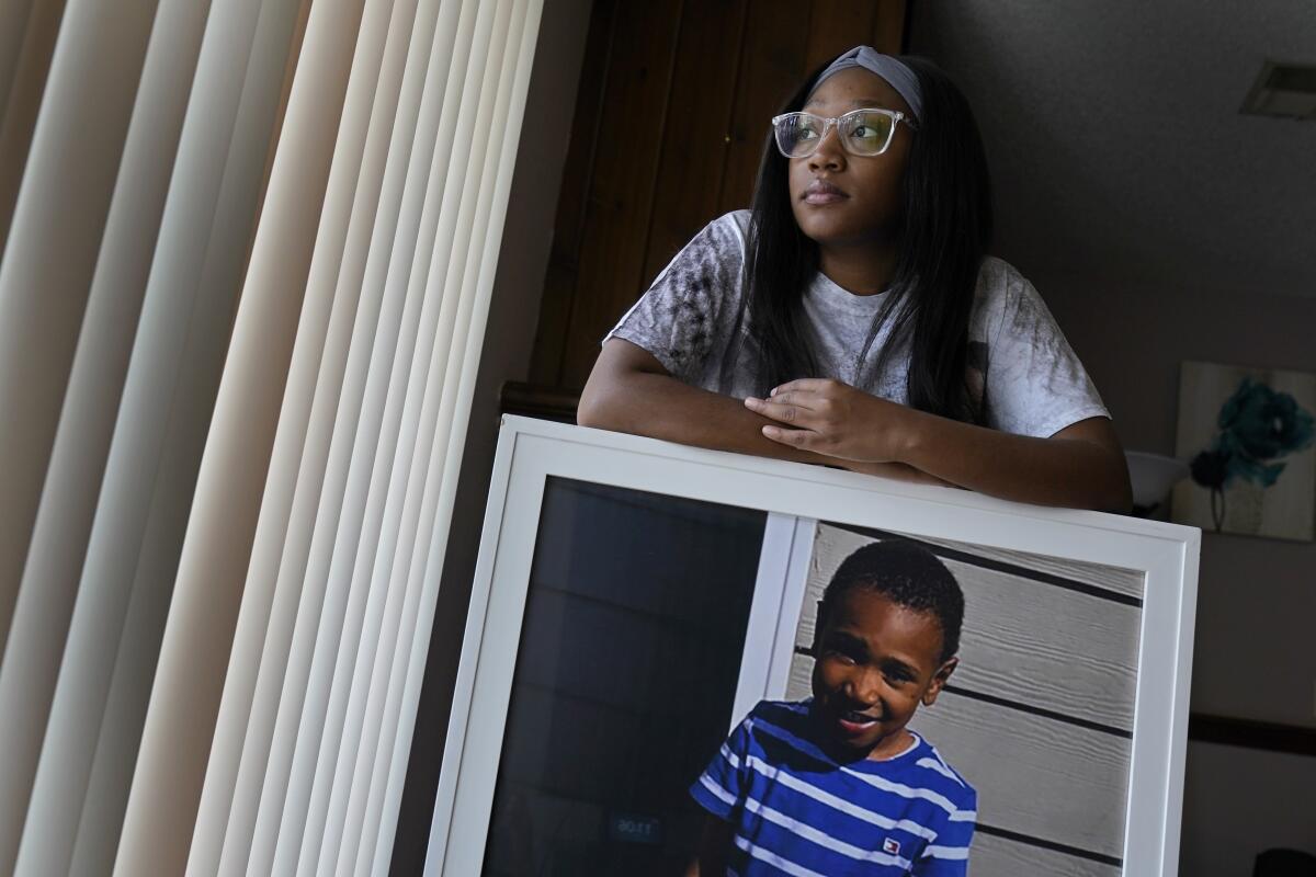 Charron Powell stands with a photo of her young son at her home.