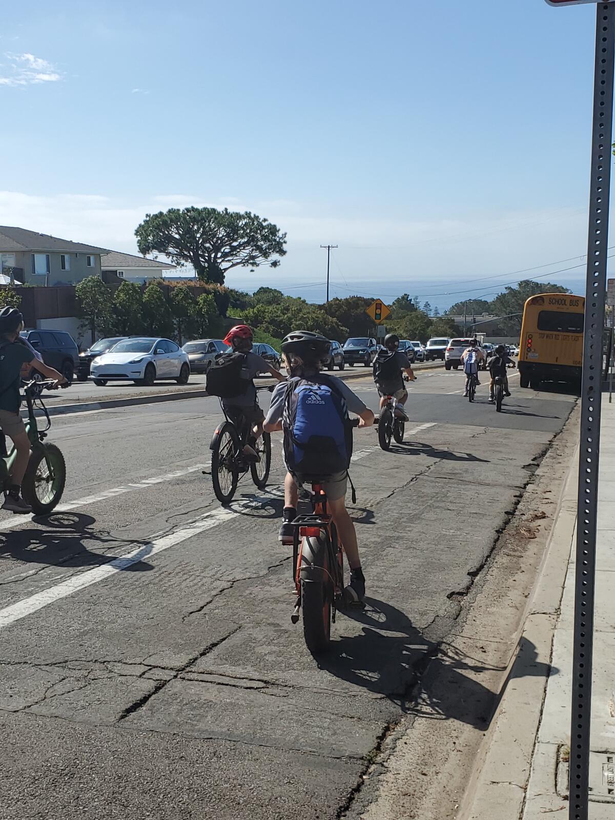 Young bicyclists leaving Muirlands Middle School ride down Nautilus Street in La Jolla.