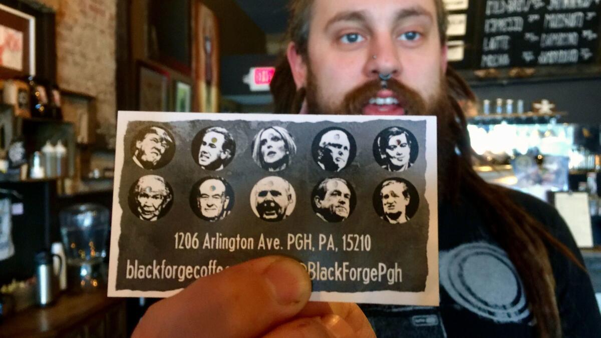 Nick Miller, co-owner of the Black Forge Coffee House in Pittsburgh's Allentown neighborhood, holds a punch card featuring President Trump and nine other conservative politicians and media icons.