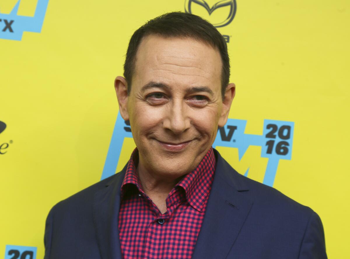 A man in a pink and black shirt smiles at a screening event.