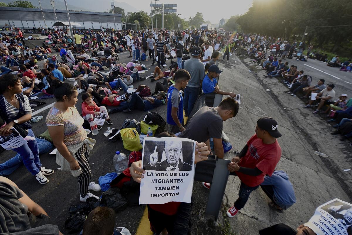Migrantes bloquean la carretera durante su caravana a través de Huixtla, México, 