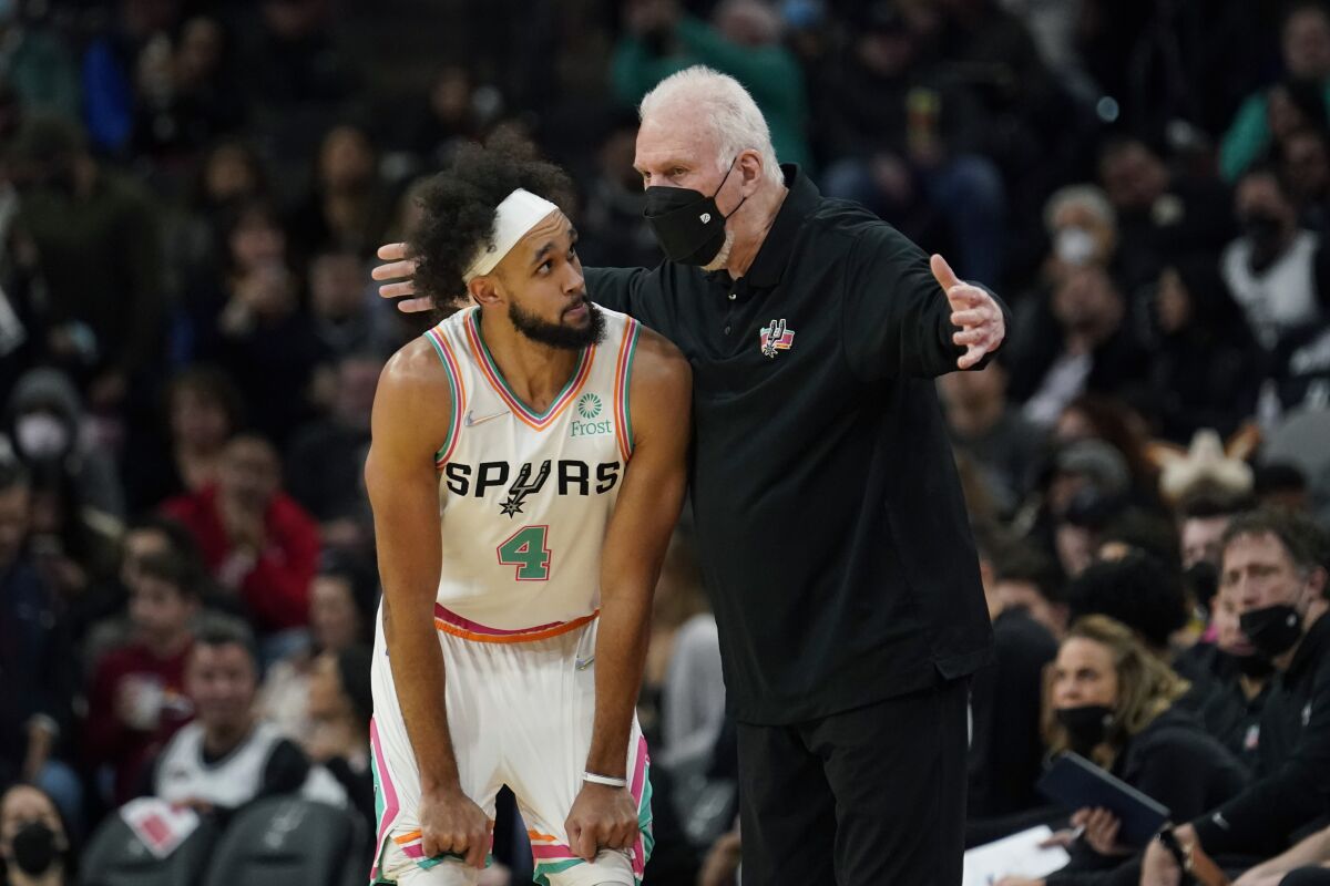 San Antonio Spurs guard Derrick White talks with coach Gregg Popovich during the second half of an NBA basketball game against the Houston Rockets, Friday, Feb. 4, 2022, in San Antonio. (AP Photo/Eric Gay)