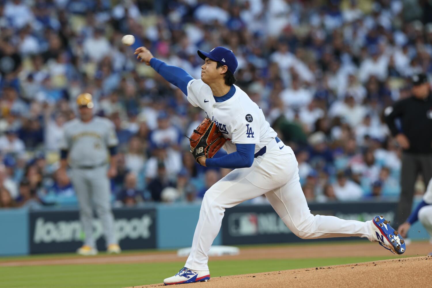 Dodgers star Shohei Ohtani delivers during the first inning against the Brewers in Game 4.