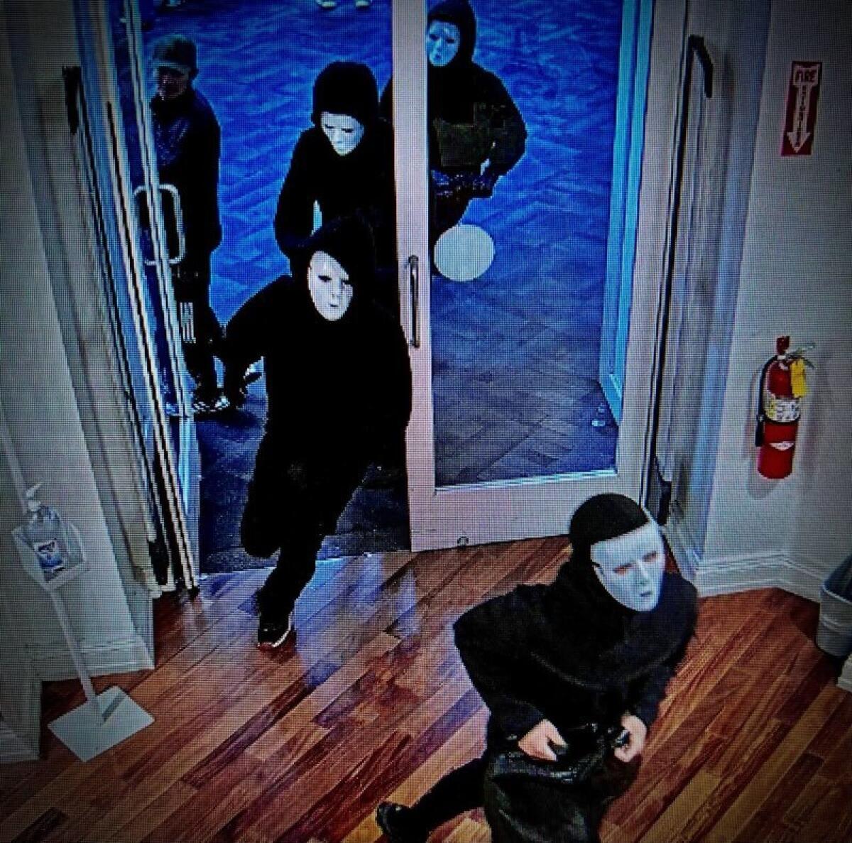 Four people in white masks enter a store.