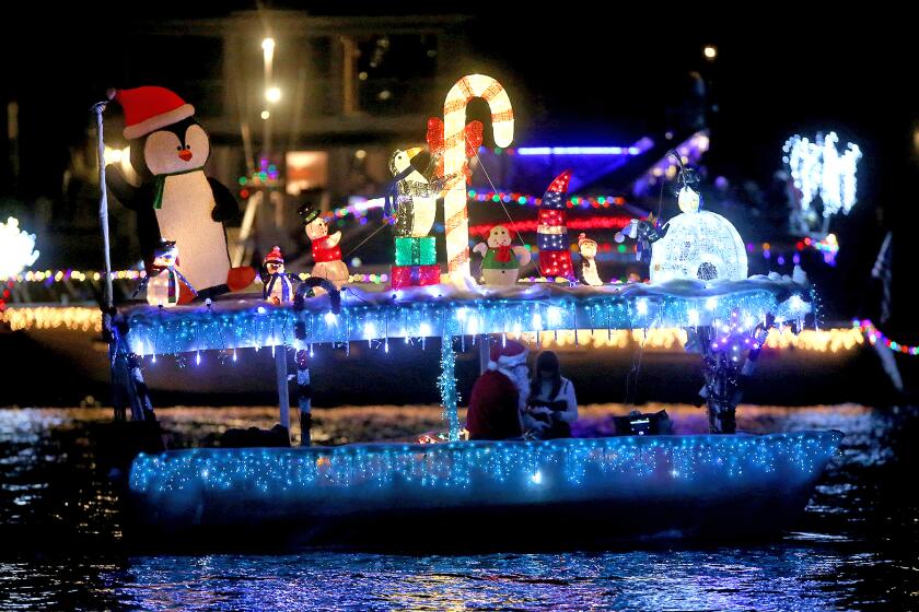 A colorful Duffy boat moves along the route during the 111th Newport Beach Christmas Boat Parade on Wednesday evening.