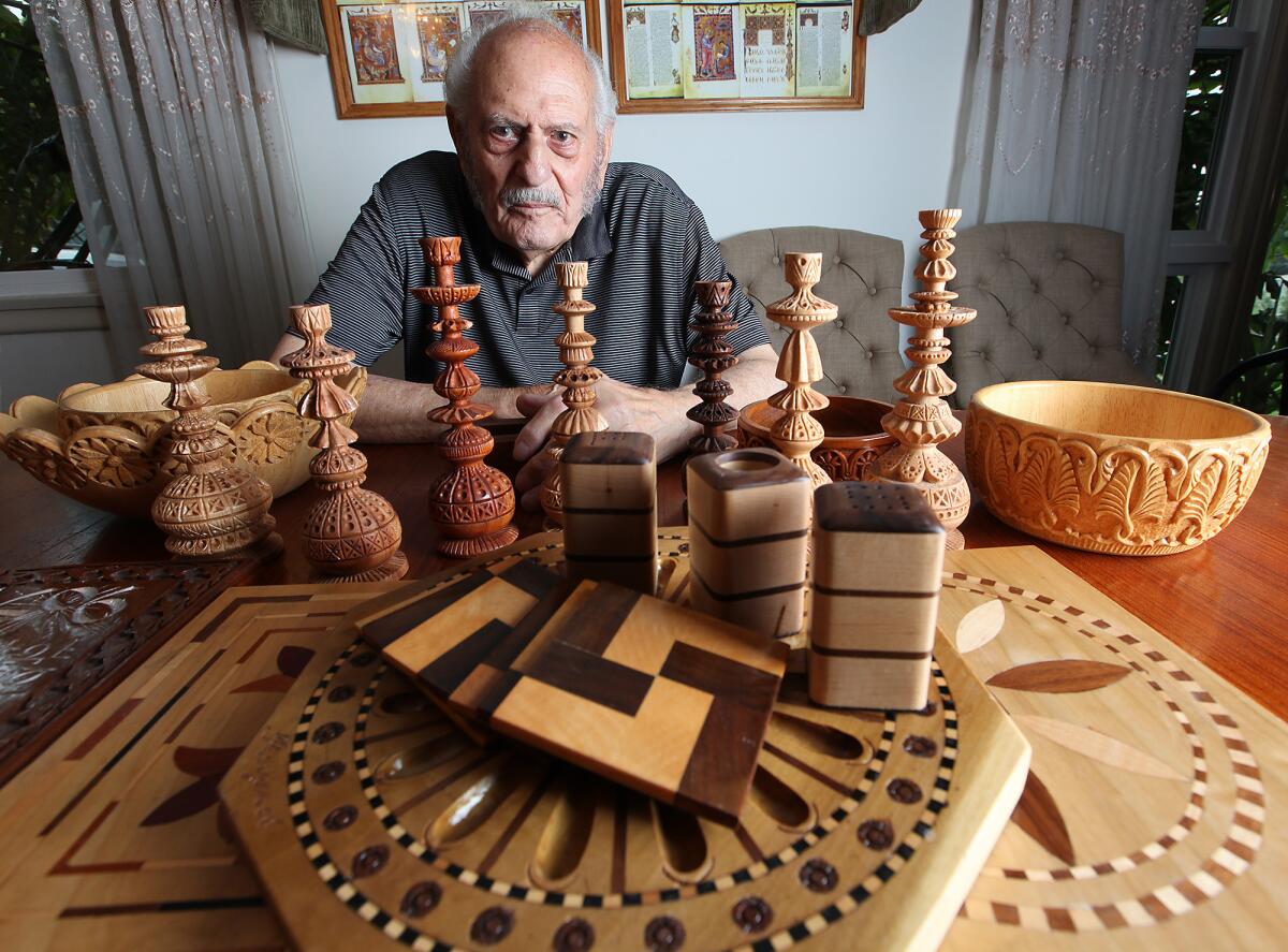 Glendale resident Goorgen Ghazarian with several of the wood pieces he's carved, which include miniature hookah replicas, bowls, salt and pepper shakers and coasters.