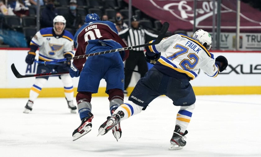 St. Louis Blues defenseman Justin Faulk, right, loses his stick after he was hit by Colorado Avalanche center Nazem Kadri during the third period of Game 2 of an NHL hockey Stanley Cup first-round playoff series Wednesday, May 19, 2021, in Denver. Kadri was removed from the game for the hit. Colorado won 6-3. (AP Photo/David Zalubowski)