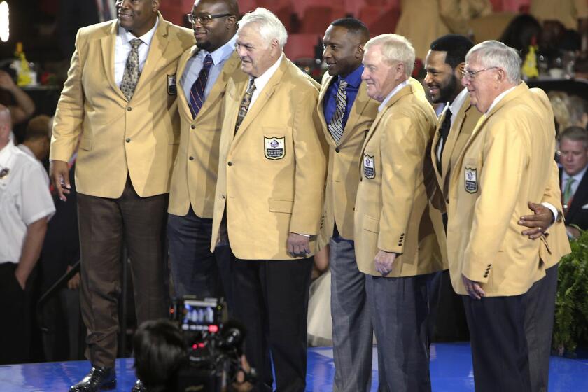 Charles Haley, left, Will Shields, Mick Tingelhoff, Tim Brown, Bill Polian, Jerome Bettis and Ron Wolf take center stage Thursday after receiving their jackets in Canton, Ohio. Class member Junior Seau was honored posthumously.