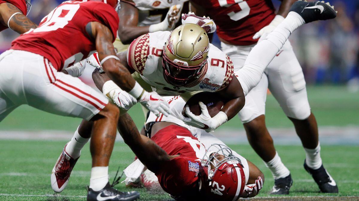 Florida State's Jacques Patrick (9) is upended by Alabama's Terrell Lewis (24) during their game on Saturday.