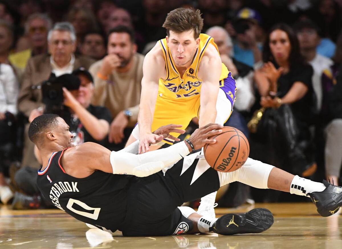 Clippers Russell Westbrook cae y pierde el balón frente a Lakers Austin Reaves.