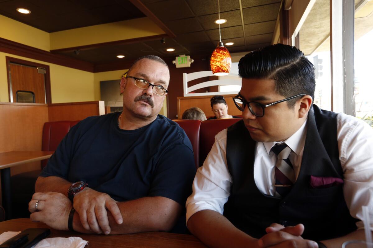 Rory Gallegos, left, talks with his housing advocate, Axel Cortes, about trying to find housing in Reseda.