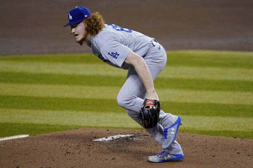 Los Angeles Dodgers starting pitcher Dustin May gets up after taking a line drive to the foot off the bat.